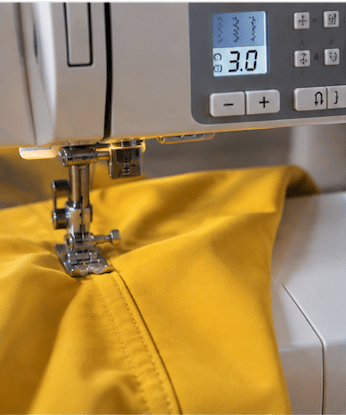 Nähmaschine mit eingestellter Stichlänge 3,0 beim Nähen von gelbem Softshell